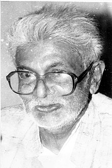 Photograph of the Malayali politician and writer A. P. Udayabhanu, depicting an older Indian man with white hair and square glasses