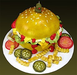 A cake sculpted to look like a cheeseburger with fries