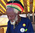Image 8Picture of Rastaman in Barbados, wearing the Rastafari colours of green, gold, red and black on a rastacap.