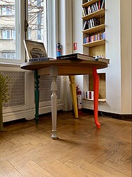 Postmodern table with different legs, some of which are reminiscent of Neoclassical furniture; unknown designer; c.2010; painted wood; unknown dimensions; Cărturești Verona (Strada Arthur Verona no. 15), Bucharest, Romania