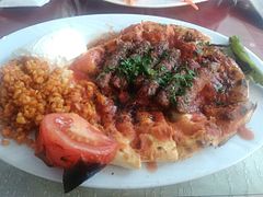 Kebab served over pide with pilav