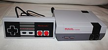 A miniature Nintendo Entertainment System dedicated console with one life-size controller.