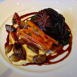 With lardons, carrots, and button mushrooms, served on parsnip purée