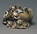 Netsuke of tigress with two cubs, mid-19th-century, ivory with shell inlay