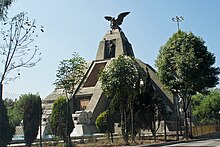 Picture of the Monumento a la Raza (Spanish for "Monument to the People"), a stone monument based on Mesoamerican pyramids. At the top, there is a statue of an eagle spreading its wings, and on the next story, there is a statue of a standing man.
