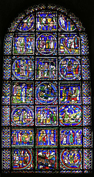 The window has a simple round-arched top. The stained glass is supported by a lead armature of squares and circles which divide it into many separate pictures. The upper pictures show the story of the Three Wise Men. The lower part has an assortment of biblical scenes including "The Sower". The background colour is deep blue.