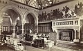 The Saloon, Eaton hall (c.1883 destroyed c.1962), note the Henry Stacy Marks murals of the Pilgrims from The Canterbury Tales, the elaborately carved marble fireplace, columns and arches, the rows of columns and arches delineate the corridor passing through the building, beyond which is the Entrance Hall with its elaborate mosaic floor.
