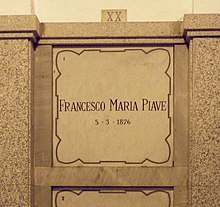 A marble gravestone on the wall of a crypt
