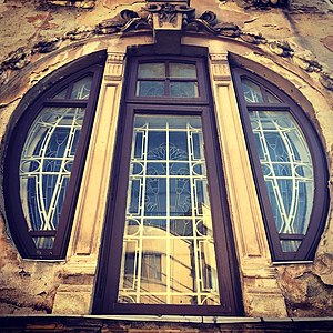 Mix of Art Nouveau and Egyptian Revival – Round corner window of the Romulus Porescu House (Strada Doctor Paleologu no. 12) in Bucharest, decorated with lotus flowers, a motif used frequently in Ancient Egyptian art, designed by Dimitrie Maimarolu (1905)[176]