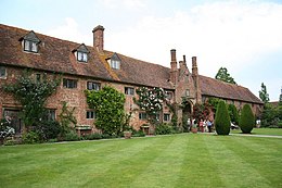 a long range of brick buildings with a central arch