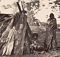 Two Aboriginal woman in front of bark gunya, c. 1850s