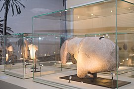 A large stone carving of an equidae - an animal belonging to the horse family. The piece itself, measuring 86 cms long by 18 cms thick and weighing more than 135kg., is a large sculptural fragment that appears to show the head, muzzle, shoulder and withers of a horse. The fact that other smaller, horse-like sculptures were found at Al-Magar, with similar bands over the shoulders, supports the idea that this culture may have been using horse tack to domesticate horses.[6]