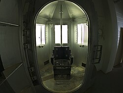 A defunct gas chamber, which is a small, reinforced room. In the middle is a metal chair with restraints for the arms and legs.