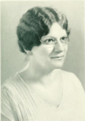 The article's subject with short hair and glasses, wearing a white shirt