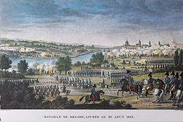 Color-tinted print showing lines of soldiers marching in very straight lines. In the middle distance is a river and on the right horizon is a city.