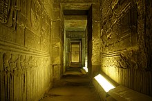 photo of interior of Dendera temple. The temple, dedicated to Hathor, is well preserved. It has a great stone roof and columns, dark chambers, underground crypts, and twisting stairways, all carved with hieroglyphs.