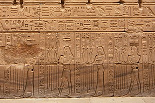 Relief showing four people with varying sets of hieroglyphs on their heads