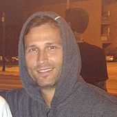 A picture of a smiling wearing a hoodie