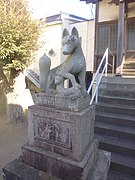 Detail view of the left fox guardian of the shrine Aratama Inari Jinja in Numazu with kit