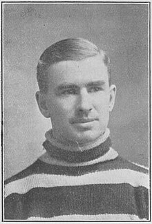 Headshot of a young man wearing a stripped sweater