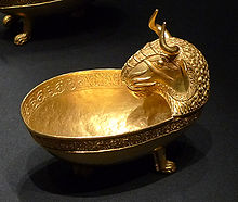A golden bowl depicting a bull's head.