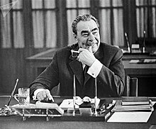 Photograph of Leonid Brezhnev seated at a desk, facing the camera