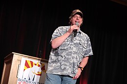 Hefty man in camouflage shirt giving a speech