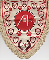 A pennant with the Aberdeen Football Club logo in a red circle in the centre, surrounded by 13 additional shields
