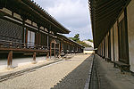 Long wooden building with white walls.