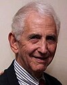 An old man in black suit and striped shirt, the whistleblower Daniel Ellsberg