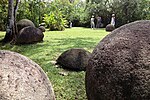 People looking at large stone spheres