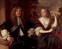 A aristocratic man and woman, both richly attired and with long curly hair, seated together outside, with a landscape behind them.
