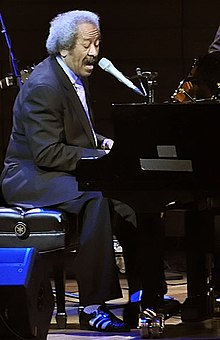 Allen Toussaint singing and playing piano at a concert in 2004