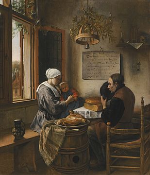 A man, woman, and infant at a table by a window