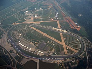 Aerial view of Talladega Superspeedway in 2007, with the runways of the defunct Anniston Air Force Base visible just to the south of the active Talladega Municipal Airport