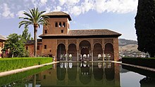 A Moorish style palace with a pool and a garden.