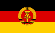 The flag of East Germany, defaced with a national emblem