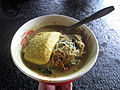 Yellow tofu (tofu colored with turmeric) on top of laksa