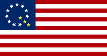 A modified version of the American flag with ten white stars and three gold stars forming a letter Q in the canton