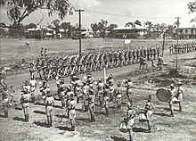 A military band on parade as a group of soldiers marches past