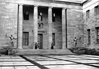 The New Reich Chancellery's Courtyard of Honor in 1939. The main entrance was flanked by Arno Breker's two bronze statues Die Wehrmacht and Die Partei ("The Armed Forces" and "The Party")