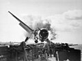 Image 27Crash landing of an F6F Hellcat into the port side 20mm gun gallery of the USS Enterprise, November 10, 1943. Lieutenant Walter L. Chewning, Jr., USNR, the Catapult Officer, is climbing up the plane's side to assist the pilot from the burning aircraft. The pilot, Ensign Byron M. Johnson, escaped without significant injury. Note the plane's ruptured belly fuel tank.