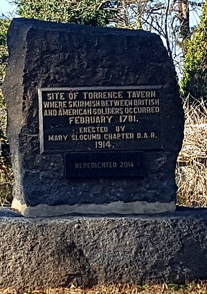 A stone marker with a metal plaque commemorating the Battle of Torrence's Tavern