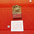 Imperial seal, decorated with a dragon, and its imprint against a red background.