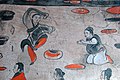 A male dancer wearing a black jiaolingpao over a pair of red trousers, Dahuting tomb, Eastern Han dynasty