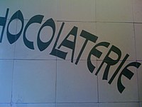 Reverse contrast lettering on tiles at a chocolaterie at The Hague, Netherlands. Date unknown.
