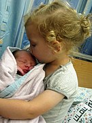 Eine Dreijährige mit ihrem Bruder weniger als einen Tag nach seiner Geburt, 7. Juli 2017
