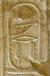 Inscription in raised hieroglyphs on a wall of light brown color