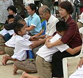 Image 50Display of respect of the younger towards the elder is a cornerstone value in Thailand. A family during the Buddhist ceremony for young men who are to be ordained as monks. (from Culture of Thailand)