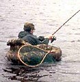 An angler in a float tube with his landing net.